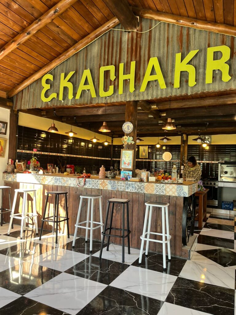 Barra de restaurante EKA CHAKRA con taburetes y suelo de baldosas. Experiencia gastronómica única.